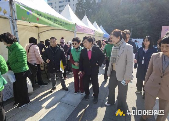 <구미경의원(베이지정장,체크목도리)가 행사에 참석하여 부스를 둘러보고 있다