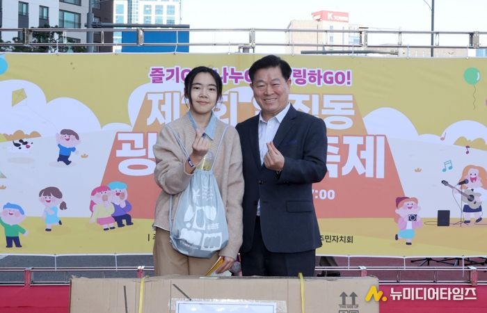 박승원 광명시장이 지난 1일 일직동 새빛공원로 차 없는 거리에서 열린 ‘제3회 일직동 광명새빛축제’에 참석해 상품을 전달하고 기념사진을 촬영하고 있다,