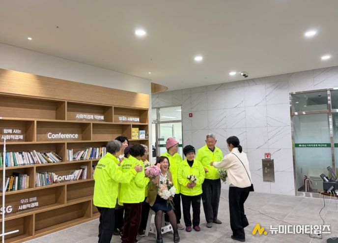 청양군노인종합복지관 강미희 관장과 2025년 노인 일자리 및 사회활동 지원사업에 참여한 어르신들이 성과보고회를 기념하며 함께 기념촬영을 하고 있는 모습.