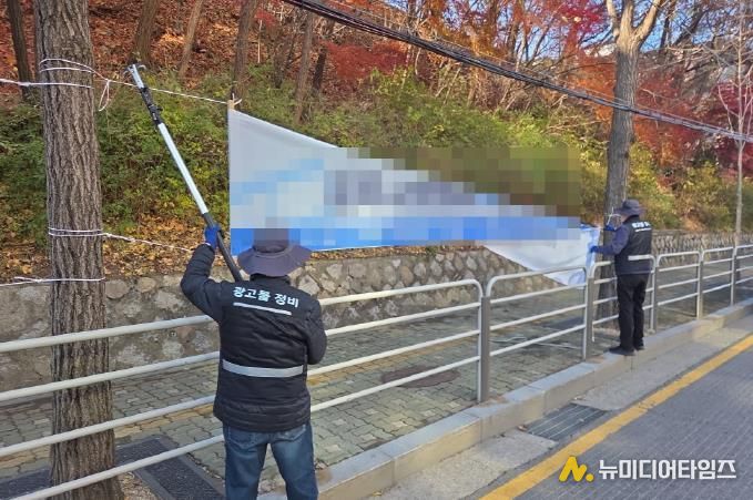 강북구 점검반이 불법 현수막을 정비하고 있다.
