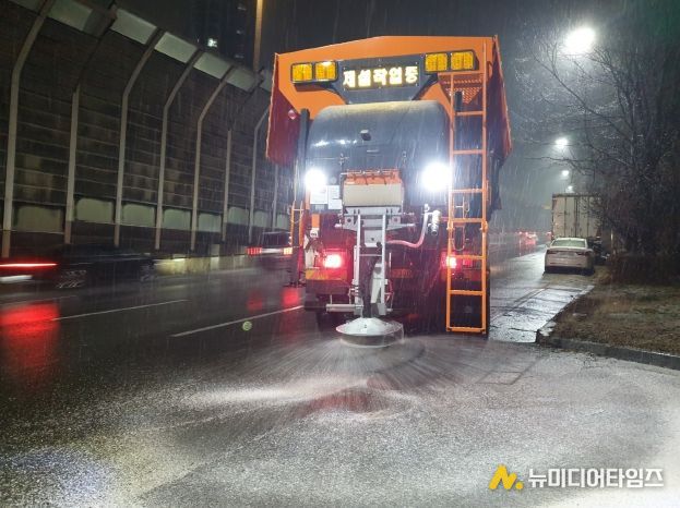 수원시가 13일 저녁 제설차량을 운행하며 제설제를 살포하고 있다.