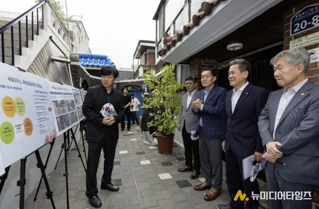 수원시와 한국보훈복지의료공단이 수원지역 독립유공자 후손의 집수리를 지원한 새빛하우스 앞에서 관계자들이 사업 설명을 듣고 있다.
