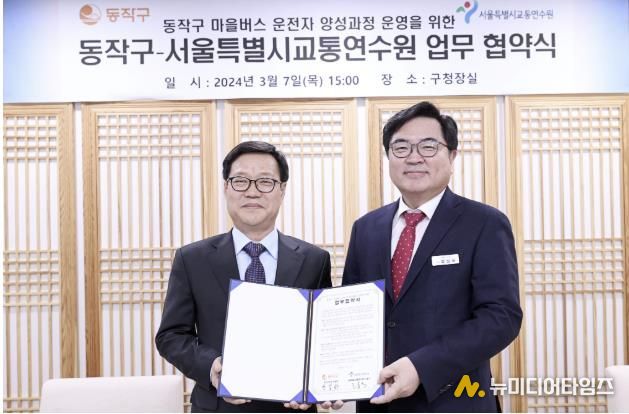 박일하 동작구청장(오른쪽)이 지난해 3월 고홍석 서울시 교통연수원장(왼쪽)과 업무협약을 체결한 후 기념 촬영하고 있다.