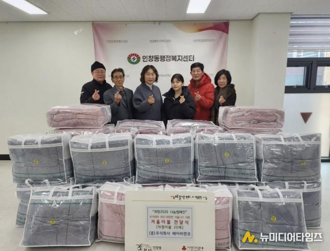 권소미 대표와 김경애 동장이 인창동 행정복지센터에서 이불 전달식을 진행하고 있다