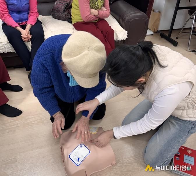 구 관계자가 경로당 어르신에게 자동심장충격기 사용법을 안내하고 있다.