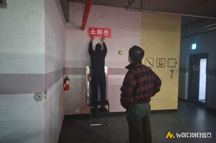 영동소방서 관계자가 아파트 지하주차장에 '보이는 소화전' 표지를 부착하고 있는 모습