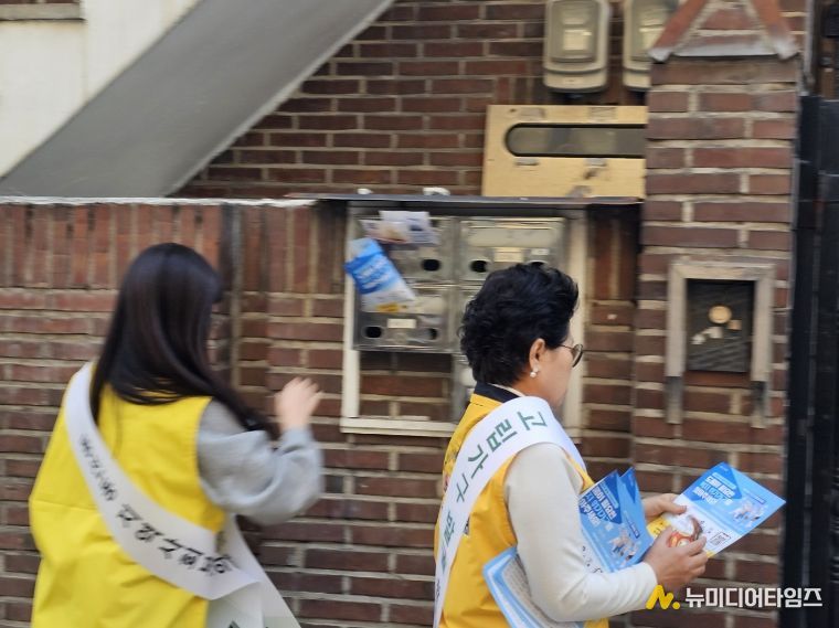 동선동지역사회보장협의체 위원들이 고립 위험가구 발굴을 위한 현장캠페인을 진행하며 안내문을 부착하고 있다.
