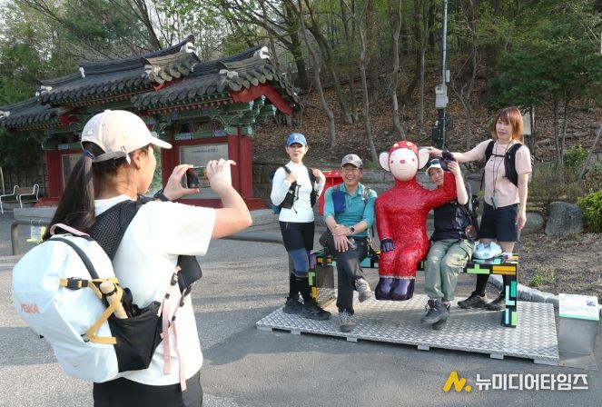관악산 등산로 입구 으뜸공원에 설치된 작품 ‘하이’와 함께 기념사진을 촬영하는 등산객들